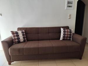 a brown couch with pillows on it in a room at Garden Home in Panormos Kalymnos +11 photos