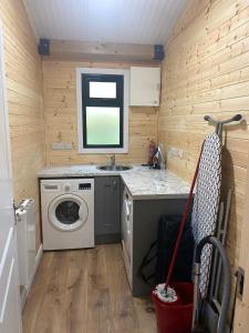 a small kitchen with a washing machine and a sink at Rosies Cabin Maum in Galway