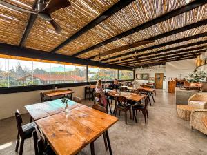un restaurante con mesas y sillas de madera y ventanas en Cava Colchagua Hotel Boutique, en Santa Cruz