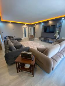 Una gran sala de estar con un sofá grande y un televisor de pantalla plana. en Sinor Home Uzungöl, en Uzungöl