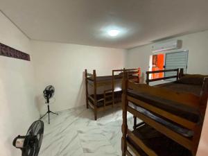 a room with three bunk beds and a fan at Casa com Piscina e Churrasqueira ótima localização in Praia Grande +40 photos