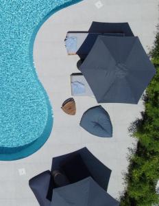 een groep parasols naast een zwembad bij Poesia Suites in Lakíthra