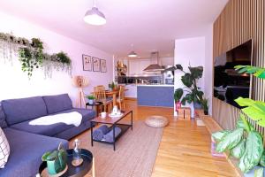 a living room with a blue couch and a kitchen at Spacious Private Flat in Sheffield City Centre in Sheffield
