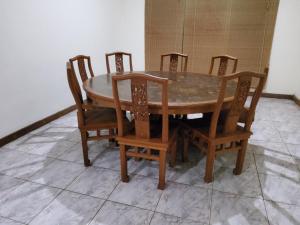 a dining room table with four chairs and a table at villa kumala in Tjikakaka +9 photos