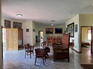 a living room with chairs and a room with a table at villa kumala in Tjikakaka