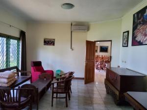 a living room with a couch and a table and chairs at villa kumala in Tjikakaka