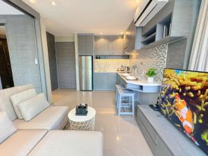 a living room with a couch and a kitchen at Modern Urban Living Kamala in Kamala Beach