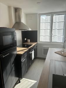 a kitchen with a stove and a microwave at Le Clos Albert in Loudun