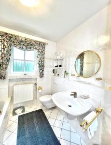 a white bathroom with a sink and a toilet at Ferienhaus Daddy Bernd in Niederstadtfeld +39 photos