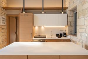 a kitchen with white countertops and a brick wall at Terra Petra Luxury Villas by Travel Pro Services- Vourvourou Halkidiki in Vourvourou