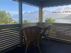 FjordgårdSegla Guesthouse - with view of Fjord的阳台上配有两把椅子，可欣赏山景