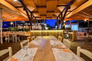 a long wooden table with wine glasses on it at Avra Hotel in Ormos Panagias