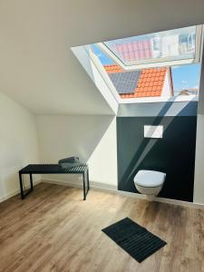 a bathroom with a toilet and a window with a roof at Hauptstadt Mitte in Waigolshausen +16 photos