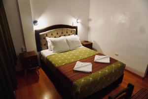 a hotel room with a bed with two towels on it at Nativus Hostel Machu Picchu in Machu Picchu