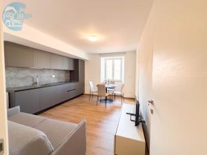 kuchnia i salon z kanapą i stołem w obiekcie Palazzo Saba Tirabora Short Rent w Trieście