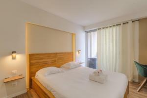 ein Schlafzimmer mit einem großen weißen Bett und einem großen Fenster in der Unterkunft Luxe et Design avec parking gratuit in Lyon