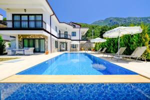 a villa with a swimming pool and a house at Mediterranean Breeze Villa - Family-Friendly Luxury Villa - Fethiye by Sunworld Villas in Fethiye