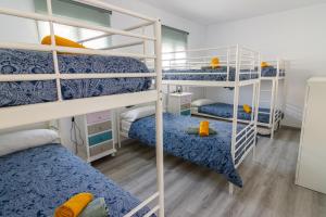 a room with four bunk beds with blue and yellow beds at Parisito Sancti Petri - Villa amplia con piscina privada in Chiclana de la Frontera +33 photos