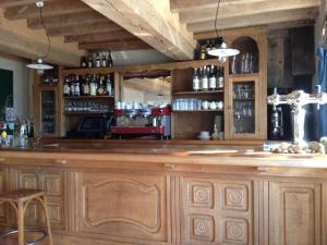 a large wooden bar in a room with wooden cabinets at Les Deux Ponts in Pierre-Perthuis
