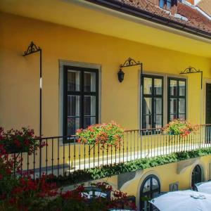 una casa amarilla con flores en el balcón en Hotel Wollner, en Sopron