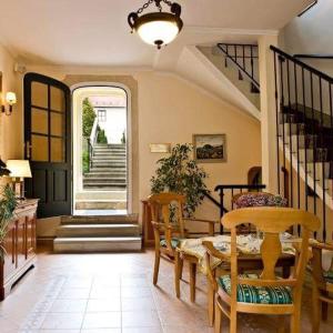 salon ze stołem, krzesłami i schodami w obiekcie Hotel Wollner w mieście Sopron