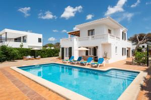 a villa with a swimming pool in front of a house at Chalet de lujo Villa Audaz in Cala Blanca