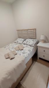 a bed with two pillows on it next to a night stand at Apartament CullerA in Cullera