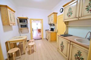 Una cocina con armarios de madera, una mesa y un fregadero. en FLH - Althaus, en Sibiu