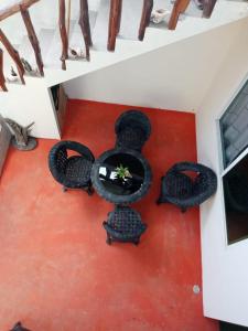 a table with four chairs on a red floor at Alojamiento el Matazarno in Puerto Baquerizo Moreno