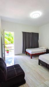 Habitación con 2 camas y sofá. en Hotel Vias Maya Bacalar en Bacalar