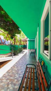 a group of benches in a building with a green wall at Hotel Vias Maya Bacalar in Bacalar