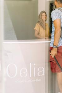 Ein Mann steht vor einem Fenster mit einer Frau in der Unterkunft Oelia Rooms & Apartments in Agia Marina