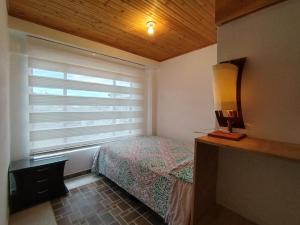 a small bedroom with a bed and a window at Casa GO in Suesca