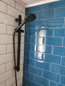 a shower head in a bathroom with blue tiles at Apartament CullerA in Cullera +43 photos
