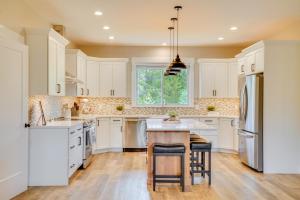 a kitchen with white cabinets and a wooden table at Spacious Donnelly Family Home with Private Hot Tub! in Donnelly