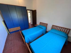 two beds in a room with blue sheets at Villetta Marino P By La Via Del Mare Viaggi e Vacanze in San Stèfano