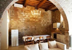 un soggiorno con divano e tavolo con sedie di Arnolfo B&B a Colle Val D'Elsa Altre 19 foto