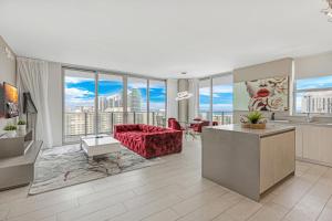 Una sala de estar con un sofá rojo y grandes ventanales. en Hyde Beach House Resort - 2BD-2BA Ocean View Luxury Resort - 5 MIN FROM BEACH - 6 GUESTS, en Hollywood