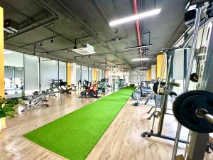 a gym with a green carpet and rows of exercise bikes at High Quality Studio In Vinhomes Green Bay Near My Dinh And Keangnam in Hanoi