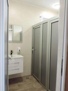 La salle de bains est pourvue d'une douche, d'un lavabo et d'un miroir. dans l'établissement Pansion Lapam, à Visoko