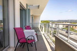 un balcón con sillas rosas y una mesa. en Sunrise - Com vista para a Vila, en São Martinho do Porto