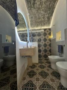 a bathroom with two toilets and a sink and a mirror at Il Pozzo Antico in Gallipoli