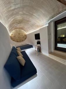 a living room with a blue couch and a window at Il Pozzo Antico in Gallipoli +14 photos