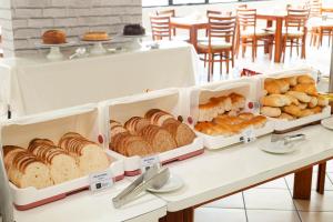 un mostrador de panadería con varias bandejas de pan y bollería en Rede Andrade Onda Mar en Recife