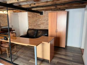 un ufficio con scrivania in legno e sedia in pelle di Cataluña Room a Barcellona