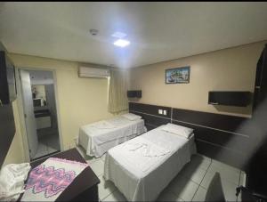 a hospital room with two beds and a table at Hotel Tropical in Porto Velho