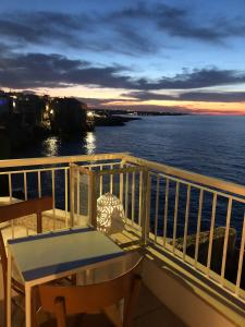 a table and chairs on a balcony with a view of the water at Bella Vista Grotta Ardito in Polignano a Mare