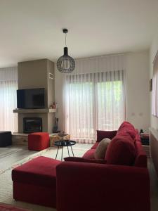 uma sala de estar com um sofá vermelho e uma televisão em Villa in Brezovica em Brezovica