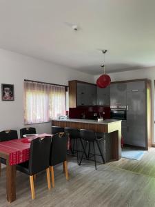 uma cozinha e sala de jantar com uma mesa vermelha e cadeiras em Villa in Brezovica em Brezovica