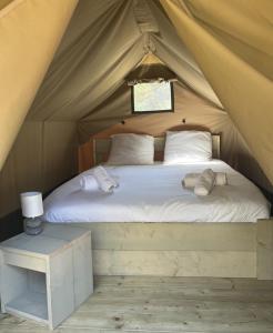 a bed in a tent with two pillows and a table at Camping Santa Elena in Lloret de Mar